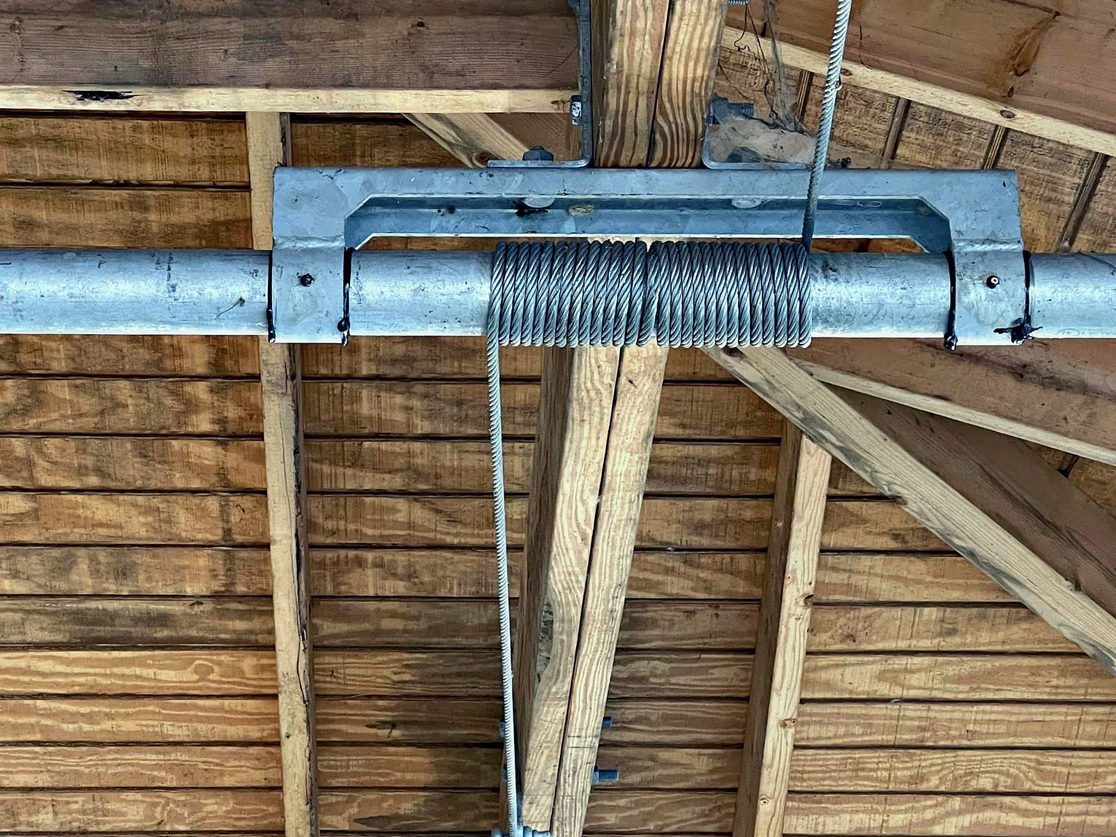 Galvanized pipe and spring hardware fitted to a boathouse frame